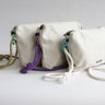 The Effie crossbody pouch shown in chalk white with three rope colour options – a military-type green, purple and white. Various carabiner colours are also shown.